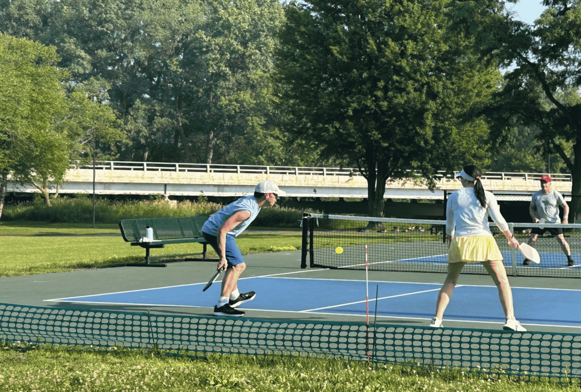 a mixed doubles pickleball team hitting a shot