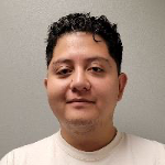Francisco wears a white t-shirt and looks at the camera