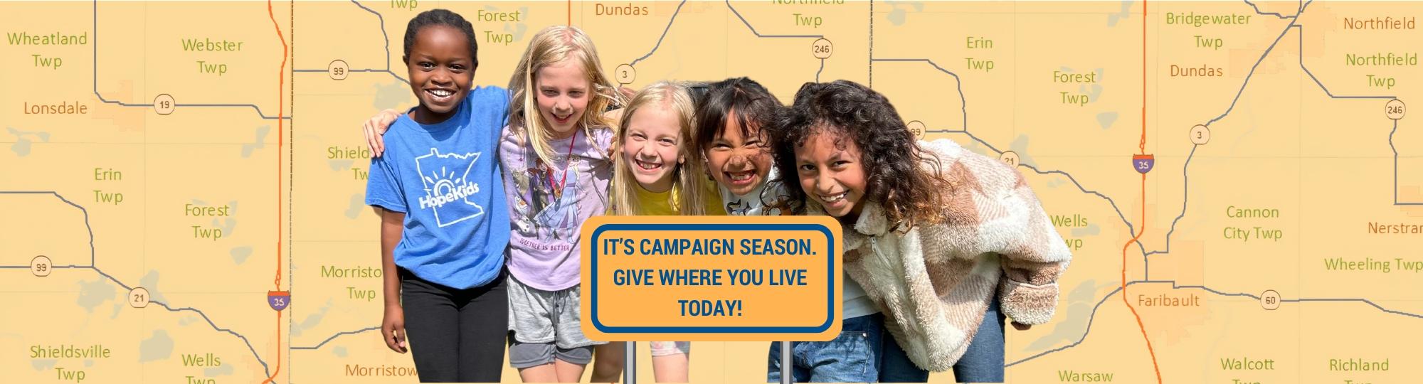 5 girls smiling with rice county map behind them and sign in front of them that says "it's campaign season. give where you live today!"