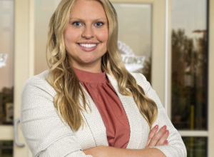Danette smiles for the camera wearing a white blazer