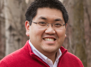 Gordon smiling at the camera wearing a red sweater