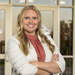 Danette smiles for the camera wearing a white blazer