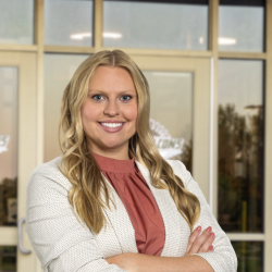 Danette smiles for the camera wearing a white blazer