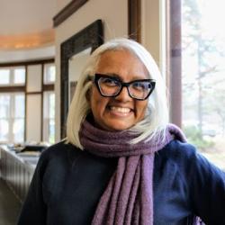 Michelle wears glasses and smiles at the camera