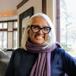 Michelle wears glasses and smiles at the camera