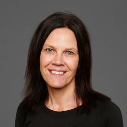 Tanya wears a black shirt and smiles at the camera